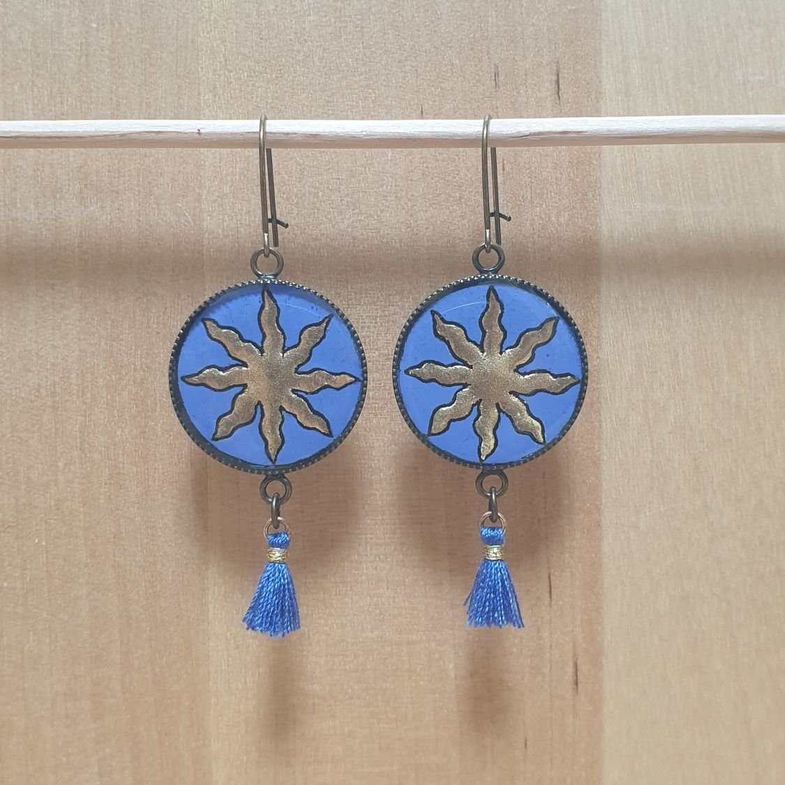 Boucles d'oreille pendantes soleil doré sur fond bleu