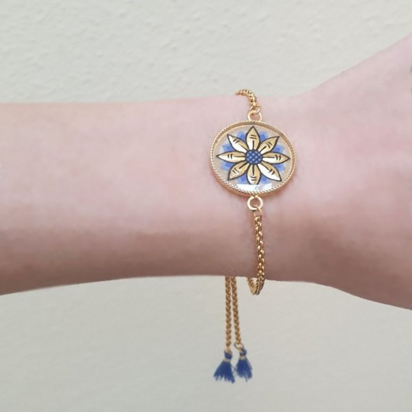 Adjustable bracelet with gold/blue flower design on gold chain