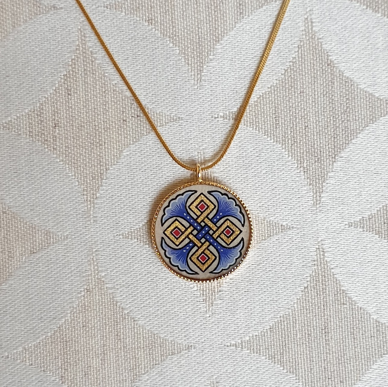 Pendant necklace illuminated blue palmettes interlaced with gold and red on gold chain