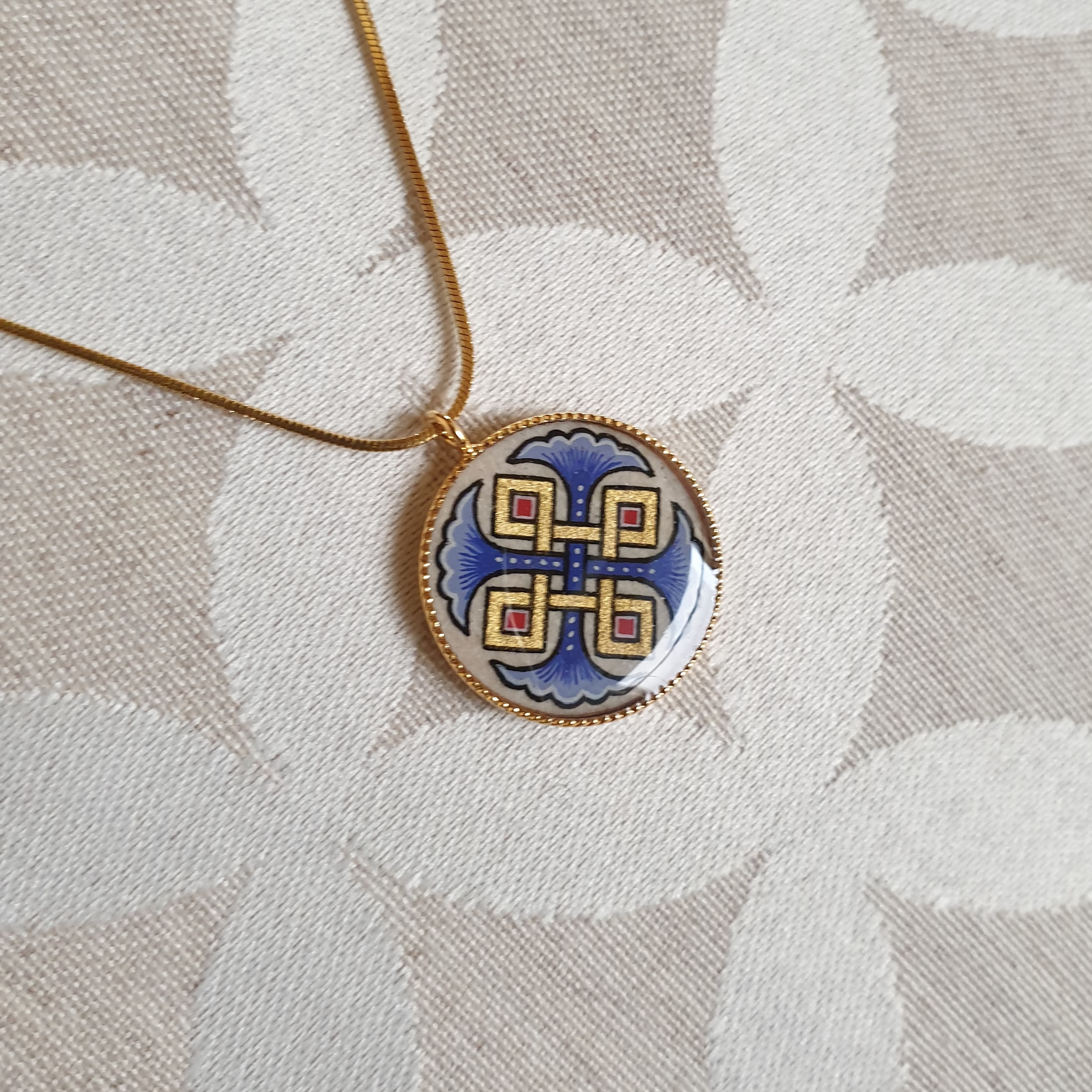 Pendant necklace illuminated blue palmettes interlaced with gold and red on gold chain