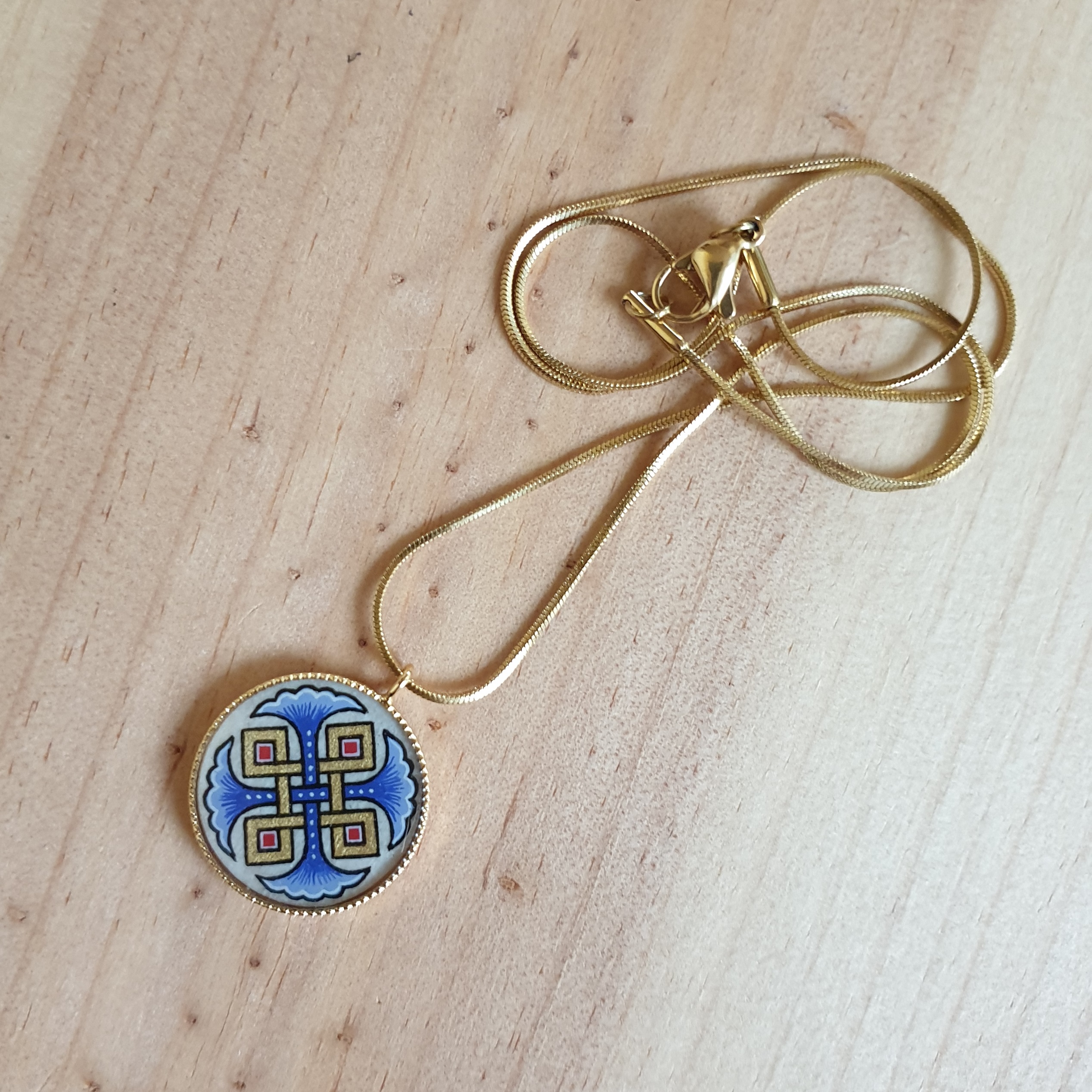 Pendant necklace illuminated blue palmettes interlaced with gold and red on gold chain