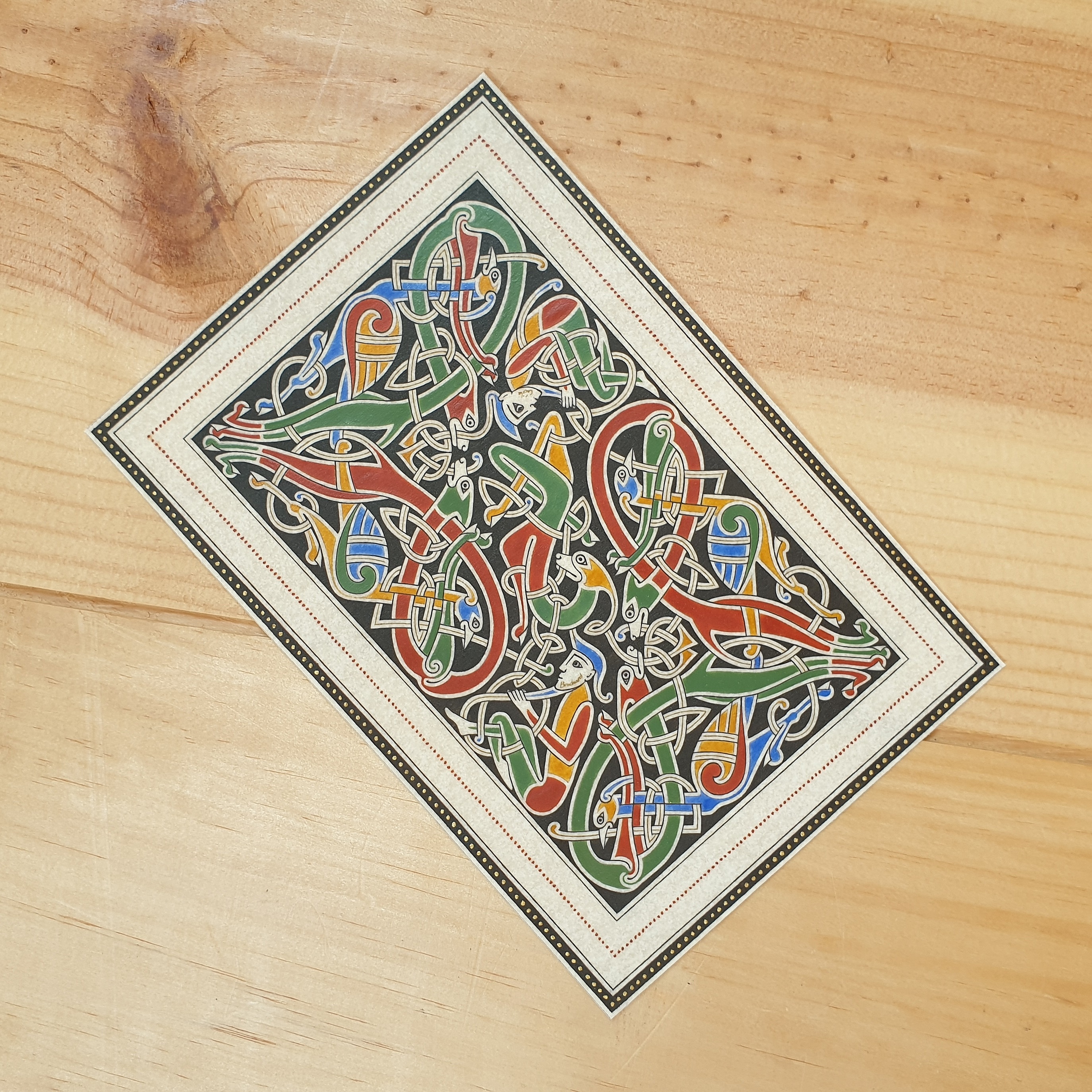 Enluminure insulaire aux entrelacs zoomorphes sur fond noir.