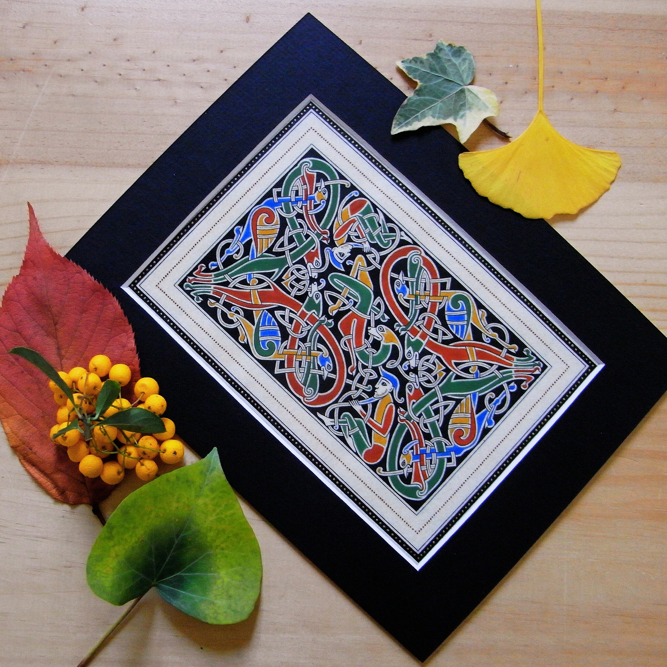 Enluminure insulaire aux entrelacs zoomorphes sur fond noir.