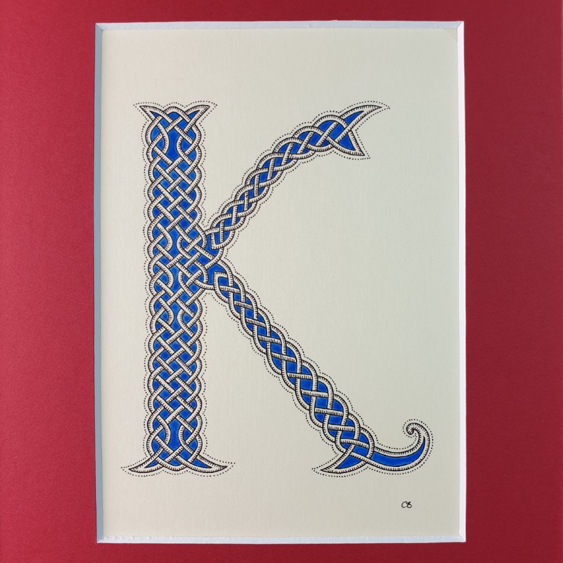 Illuminated letter K with interlacing