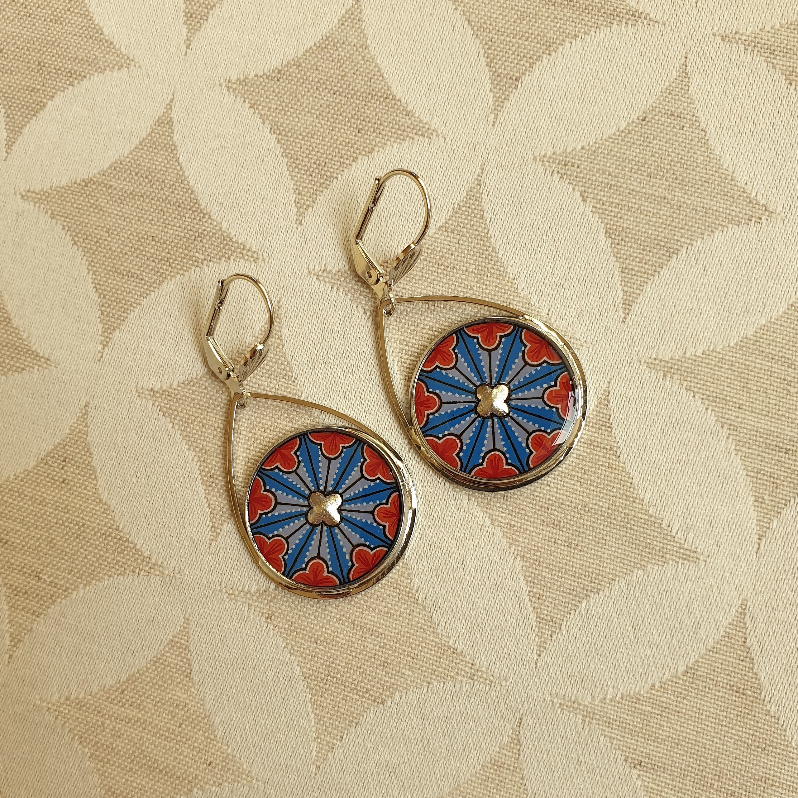 Boucles d'oreilles pendantes avec motif rosace gothique enluminé.